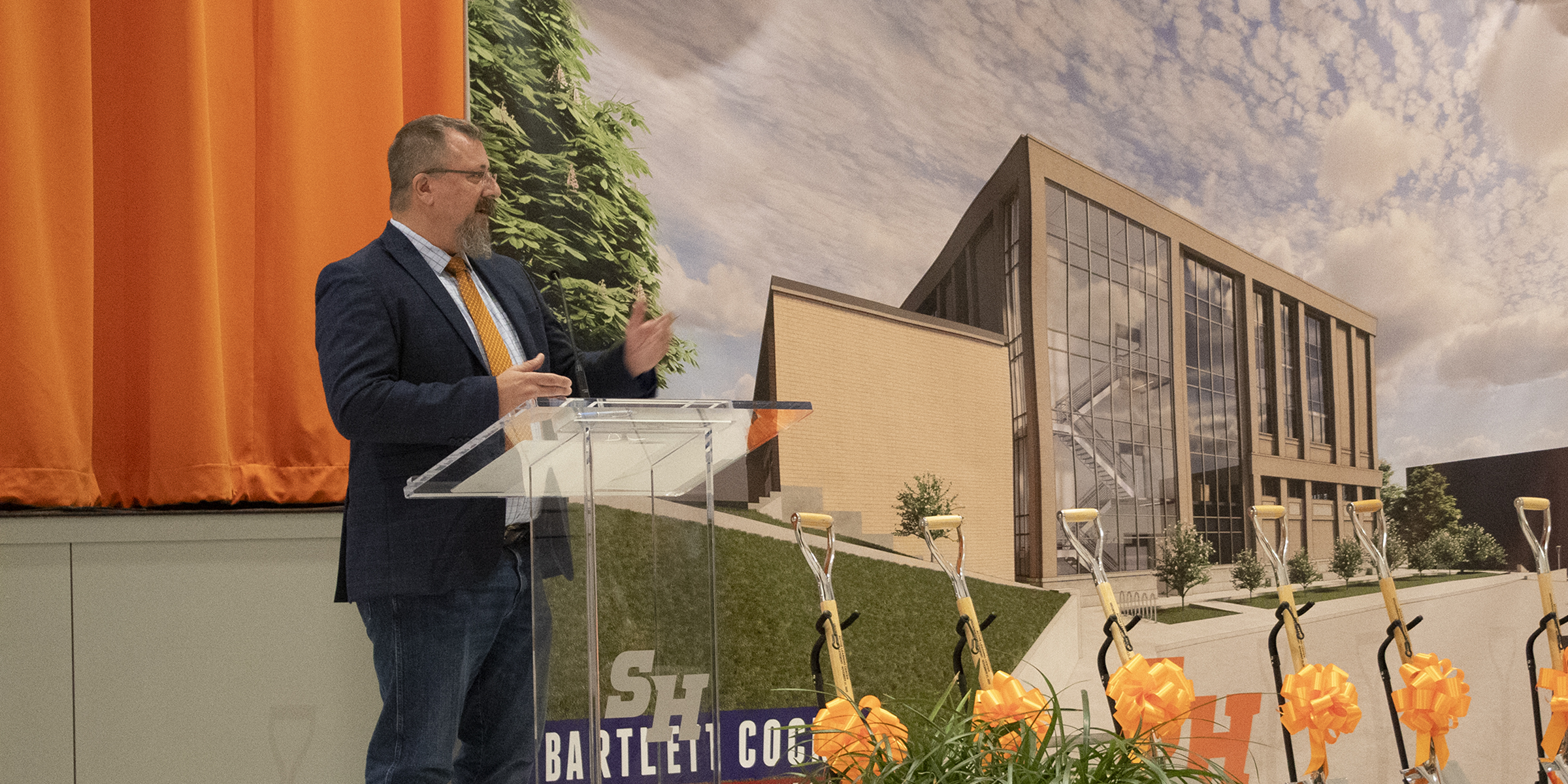 Man standing at clear podium speaking