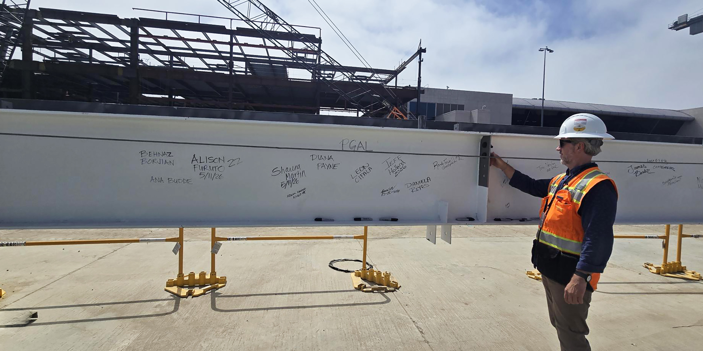 Man signing topping out steel beam